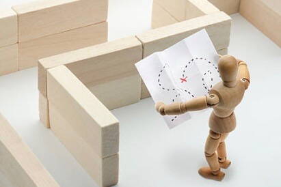 Einführungszeit - Holzpuppe steht vor Labyrinth Einführungszeit - Holzpuppe steht vor Labyrinth
