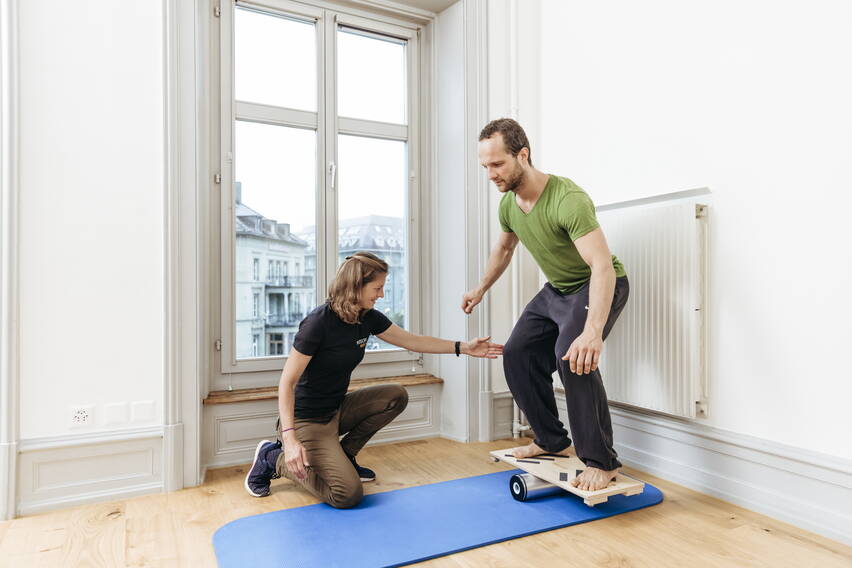 Physio - Patient auf Balancebrett Physio - Patient auf Balancebrett