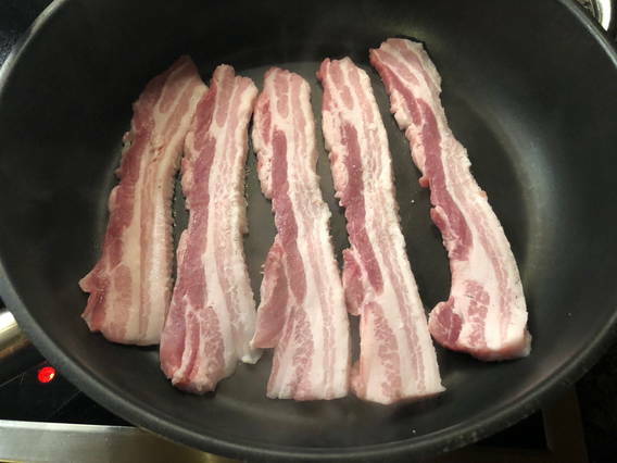 Schweinebauch, ungekocht in Bratpfanne Schweinebauch, ungekocht in Bratpfanne
