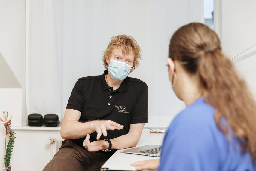 Chiropraktik Beratung. Chiropraktor spricht mit Patientin Chiropraktik Beratung. Chiropraktor spricht mit Patientin