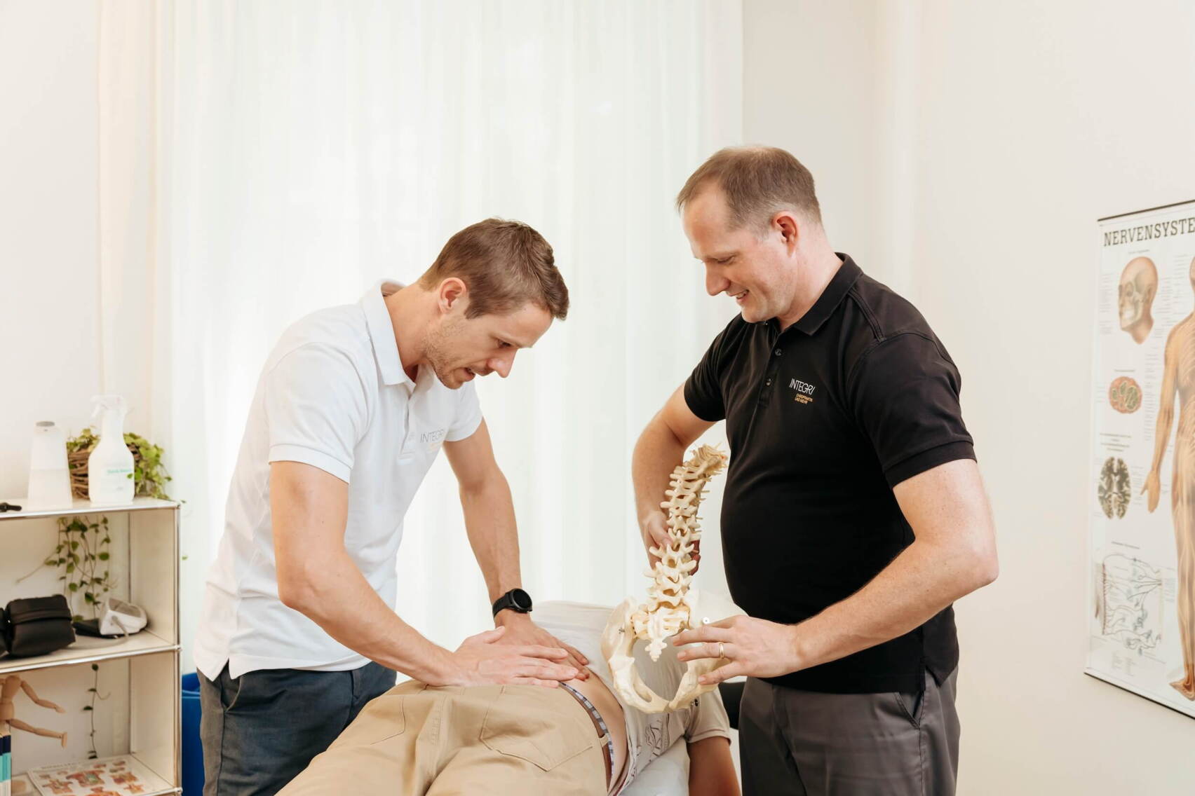 chiropraktik-behandlung-unterer-ruecken.jpg Nahaufnahme einer chiropraktischen Behandlung im Lendenbereich, bei der ein Therapeut gezielte Handgriffe an der Wirbelsäule durchführt.